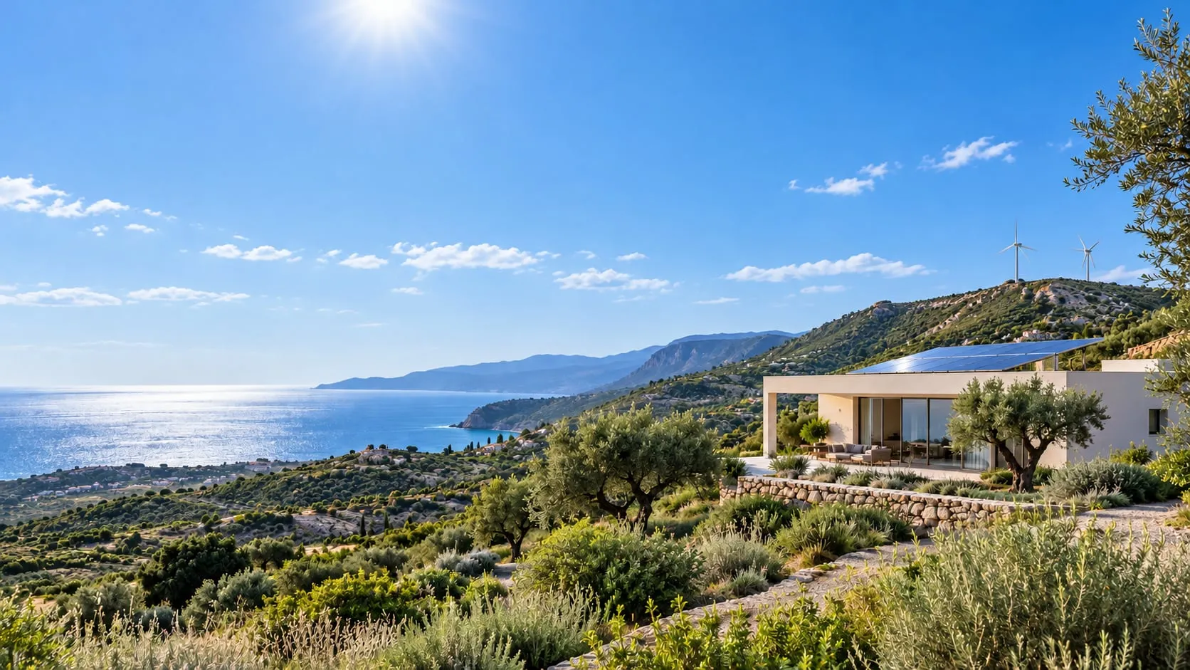 La stessa casa a mezzogiorno, sotto il sole, con il mare blu e le pale che girano sul crinale